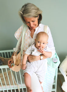 Grand mère portant le lange bebe personnalise roseta design sur son epaule